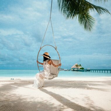 Woman in swing on beach in Maldives