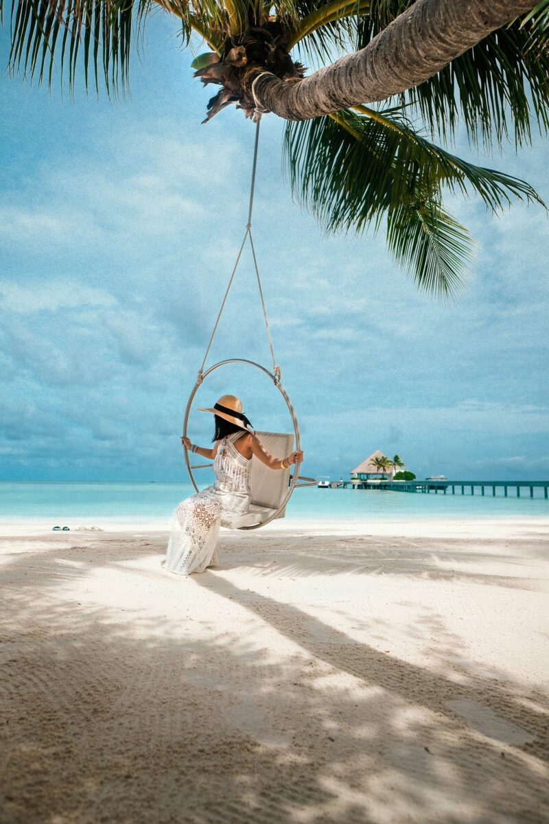 Woman in swing on beach in Maldives